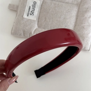 Gros plan d'un serre-tête vintage en cuir rouge avec une texture brillante et rembourrée