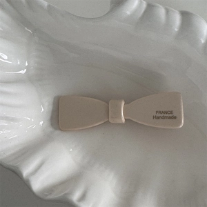 Détail de la pince à cheveux nœud en acétate crème avec lettrage France Handmade fait main