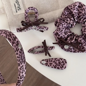 Vue détaillée d'un ensemble de pinces à cheveux et accessoires avec motif léopard rose