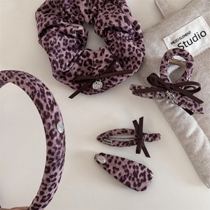 Détail d'accessoires cheveux léopard rose avec finitions nœud en cuir fait à la main