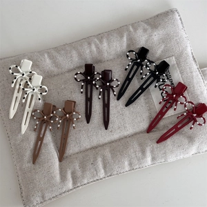 Set di fermagli per capelli con fiocchi a pois in cinque colori su lino beige