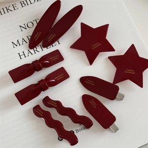 Set of burgundy red hair clips in star and bow shapes with gold handmade lettering