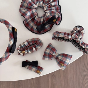 Detail view of 5-piece red and green plaid hair accessory set with gold love tag