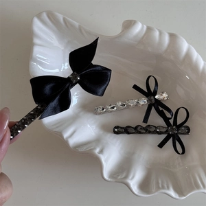 Lot de barrettes à nœuds en satin noir avec strass brillants dans un plateau élégant