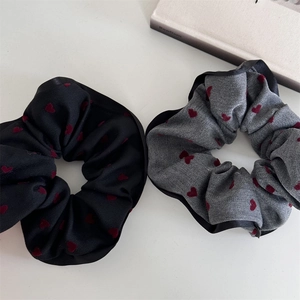 Detail of fabric scrunchies with red heart patterns and black satin borders