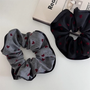Close-up of black and grey heart print scrunchies with elegant scalloped edges