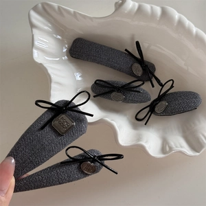 Lot de cinq barrettes à cheveux en tweed gris avec nœuds noirs et détails en métal