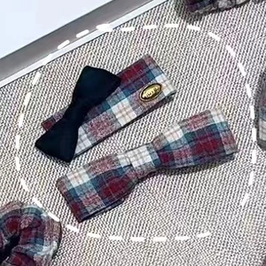 Detailed view of red and blue plaid bow hair clips with classic vintage preppy style fabric