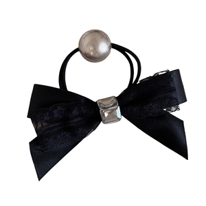 Elegant black bow hair tie with crystal centerpiece and large pearl on white background