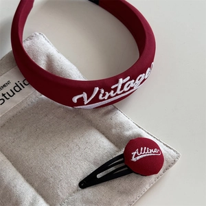 Close-up of wine red embroidered vintage fabric headband and matching round hair clip set