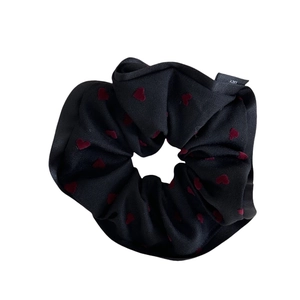 Elegant black scrunchie with red velvet hearts and a woven label for hair styling