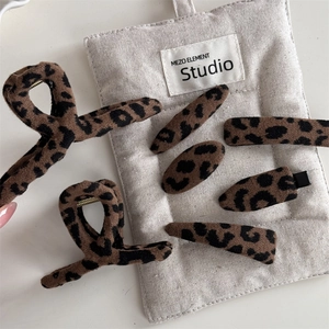 Dettaglio set di mollette per capelli leopardate con trama in tessuto morbido