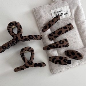 Set di mollette e fermagli per capelli maculati con texture opaca su fondo lino