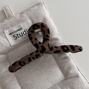 Dettaglio del fermaglio per capelli leopardato con texture in tessuto e molla in metallo