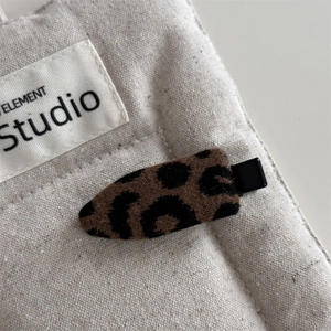 Dettaglio macro della molletta per capelli leopardata con base in metallo nero vintage