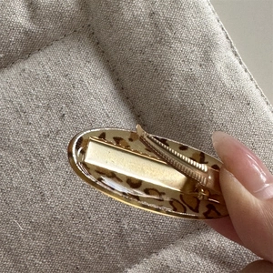 Detailed back view of leopard print oval hair clip with gold metal duckbill mechanism