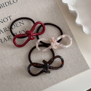 Detailed macro view of acetate knot elastic hair ties in marble and tortoiseshell patterns