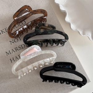 Set of four French acetate hair claws in tortoiseshell, green marble, pearl white, and black