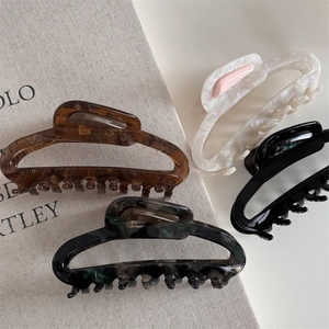 Set of four French acetate hair claws in tortoise shell, marble green, pearl, and black finishes