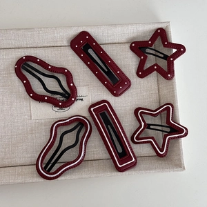 Detail of 6-piece wine red leather star and cloud hair clips with white polka dot patterns