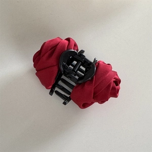 Close-up of red satin rose hair claw clip with detailed petals and smooth texture