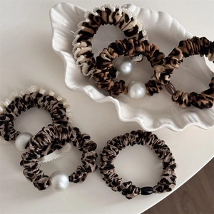 Chouchous léopard chic avec perles et dentelle présentés dans un plateau coquillage
