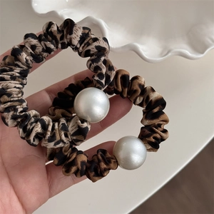 Gros plan d'un lot de chouchous léopard avec de grandes perles blanches élégantes décoratives