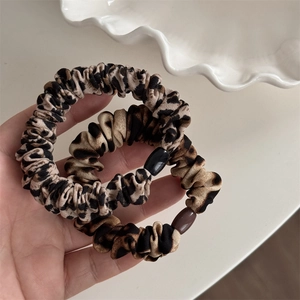 Gros plan de chouchous léopard en tissu plissé avec boucles ovales brillantes