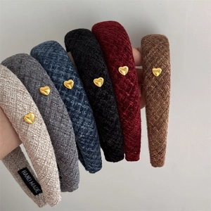 Detailed view of plaid tweed padded headbands with gold heart buckles in multiple colors