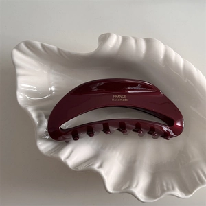 Dettaglio di una molletta bordeaux con scritta dorata France Handmade su vassoio bianco