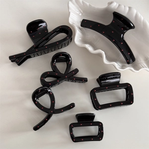 5-piece set of black French hair claws with red polka dots on a decorative plate