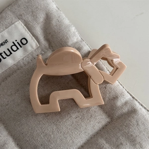 Detail van beige acetaat honden haarklem met glanzende afwerking en metalen veer detail