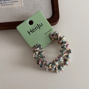 Detailed view of colorful woven elastic hair bands on a white display board