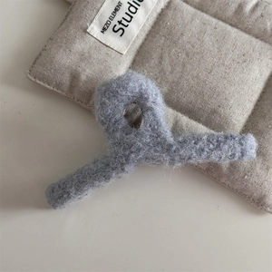 Vue détaillée de la pince à cheveux en peluche bleu clair avec texture douce et pailletée