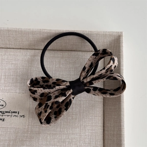 Dettaglio del fermaglio per capelli con fiocco leopardato ed elastico in scatola