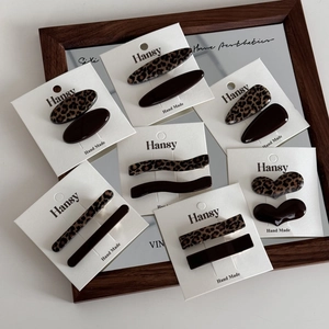 Elegantes Haarspangen-Set mit Leopardenmuster in verschiedenen Formen auf Spiegelhintergrund