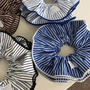 Close-up of blue striped scrunchie with layered ruffles and delicate bow embroidery