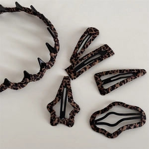 Macro shot of 5-piece leopard print hair accessory set with headband and varied BB clips