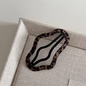 Close-up of leopard print fabric-wrapped hair clip with black matte metal frame