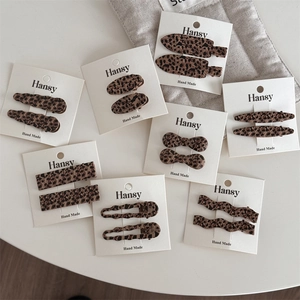 Detailed close-up of leopard print hair clips in various shapes on display cards