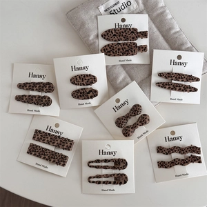Set of vintage leopard print hair clips with various shapes on a white display card