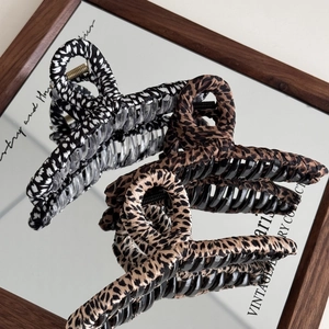 Three animal print leopard hair claws with fabric texture and vintage design shown on mirror