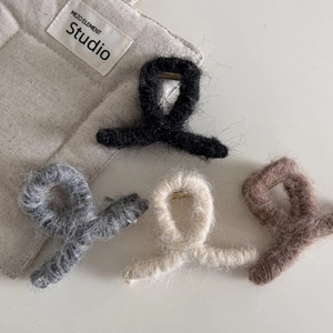 Pinzas para el pelo de peluche en cuatro colores como beige, gris y negro sobre blanco
