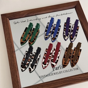 Leopard print non-marking hair clips set in diverse colors on a vintage mirror tray