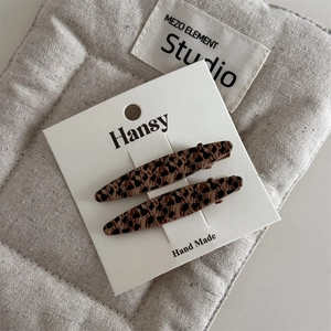 Detail of two leopard print hair clips with tortoiseshell pattern on white card display