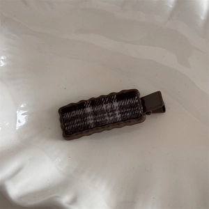 Detail of sweet cherry style plaid hair clip with wave edges and grey checkered pattern