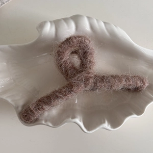 Detalle de pinza para el cabello de felpa marrón con textura de mohair suave y densa