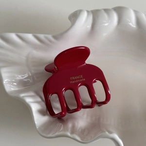 Detailed macro view of wine red acetate hair claw with France Handmade gold lettering