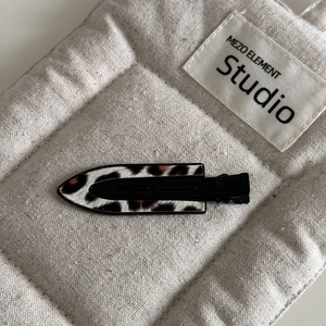 Detailed view of the leopard print hair clip texture on a soft fabric surface