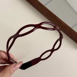 Detailed macro view of the dark red geometric hollow headband with comfortable fabric tips